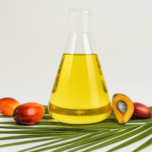 Cosmetic-grade palm oil in a glass flask with palm fruits and a palm leaf - carrier oil for balms, soaps and moisturizers.