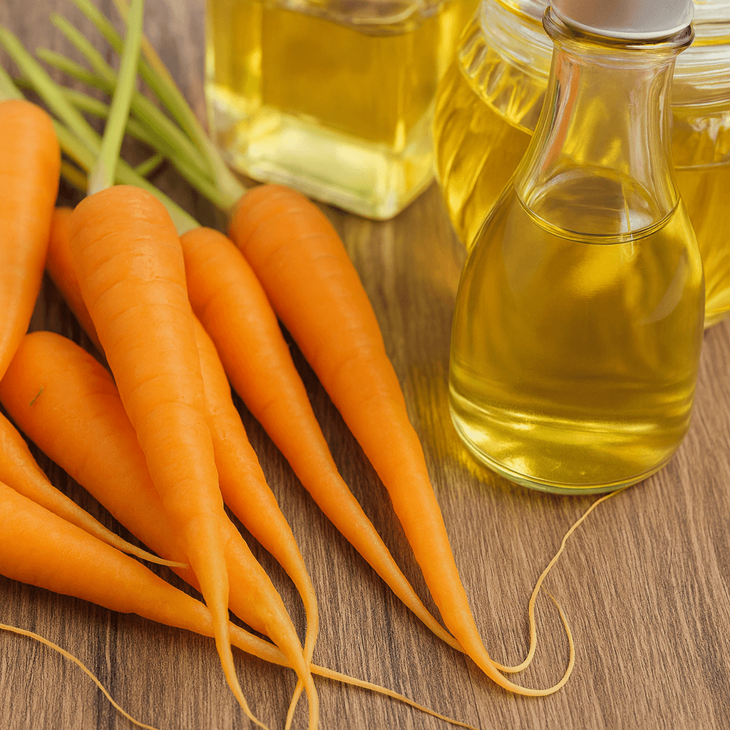 Fresh carrots with glass bottles of carrot oil on wooden background